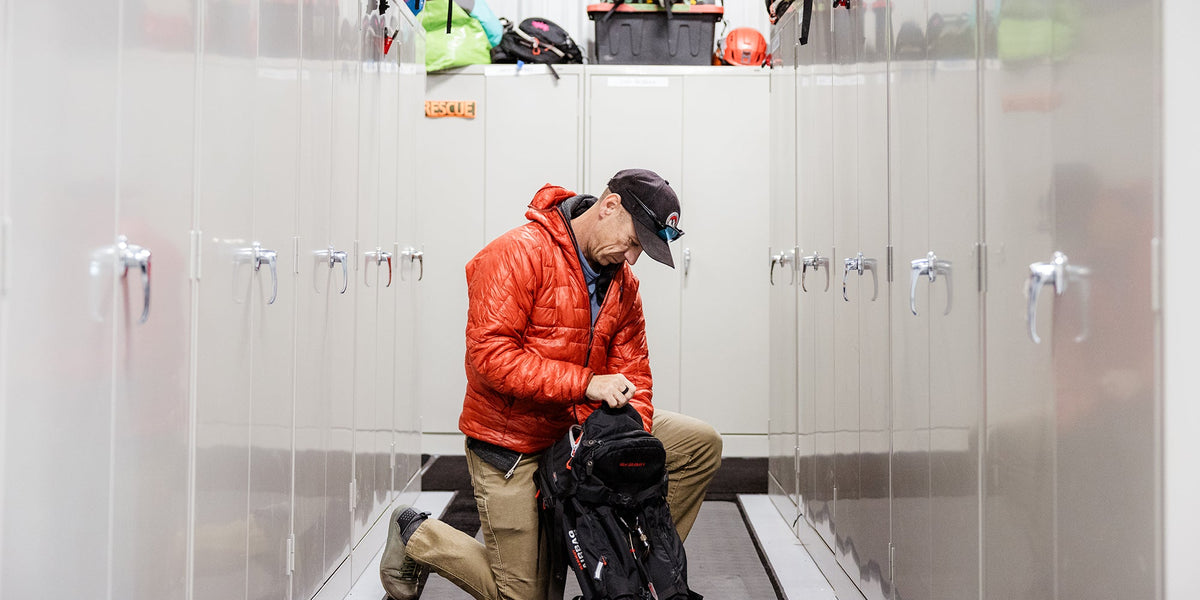A man reaches into his bag in a locker room
