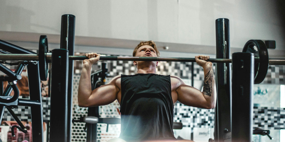 a muscular man does a chest press in a gym