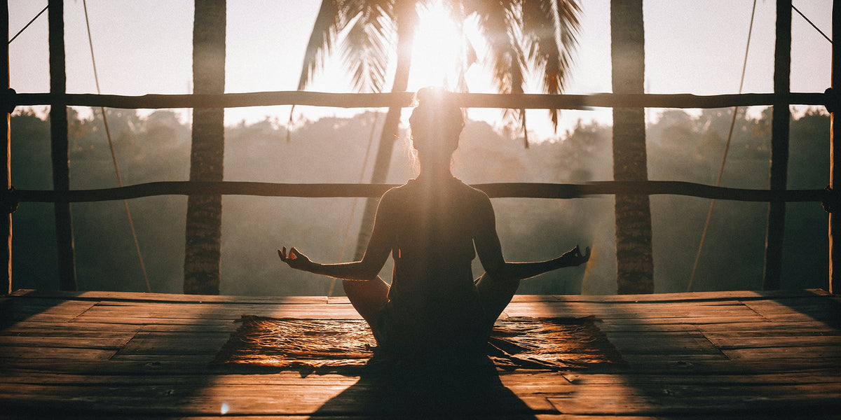 A woman meditates in the morning sunlight