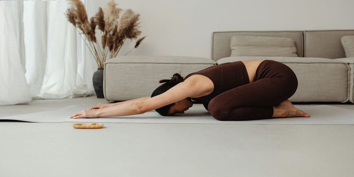 a woman does a yoga pose on the floor