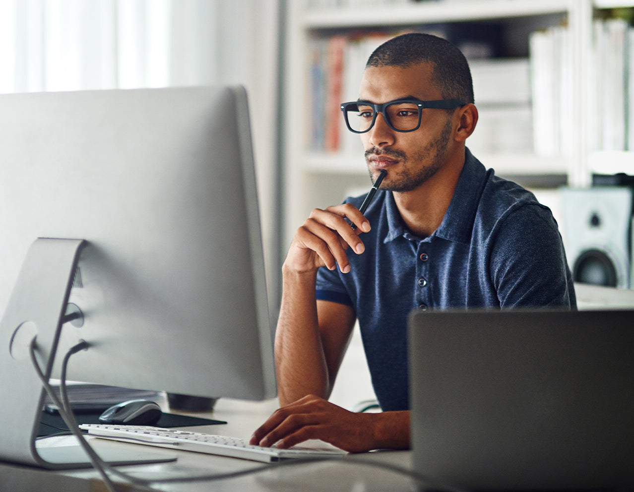 Man sitting at desk with computer focusing