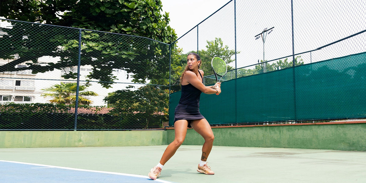 A female tennis player prepares to hit a backhand on a tennis court