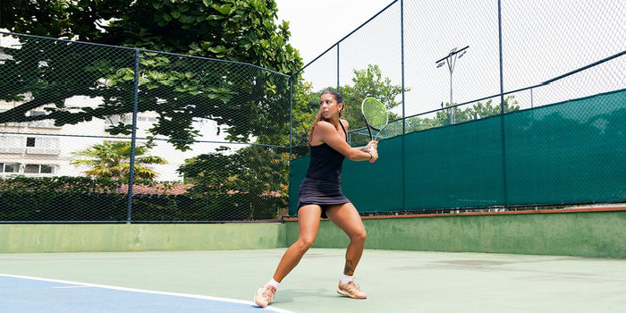 A female tennis player prepares to hit a backhand on a tennis court