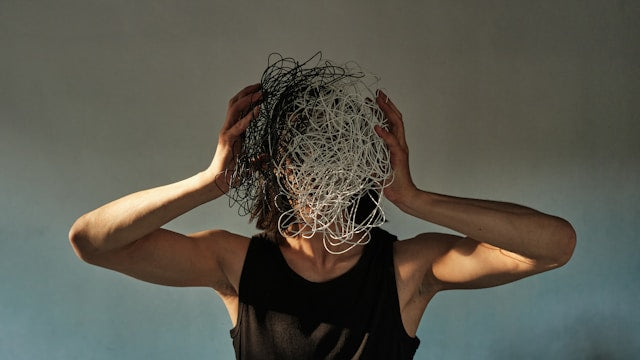 A woman with a ball of string in front of her face