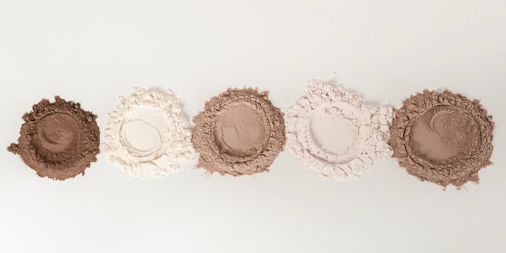 five different scoops of protein powder shot from above