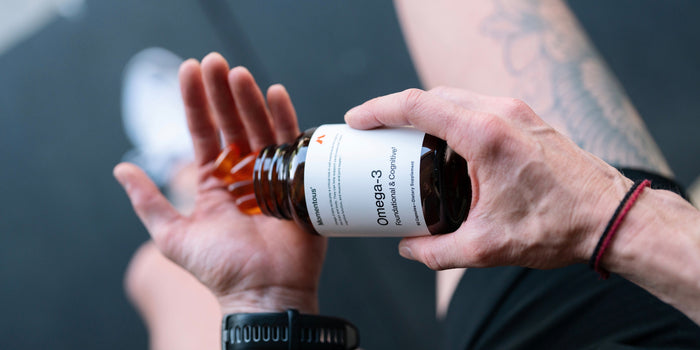 A man pours Momentous Omega-3 capsules into his hand