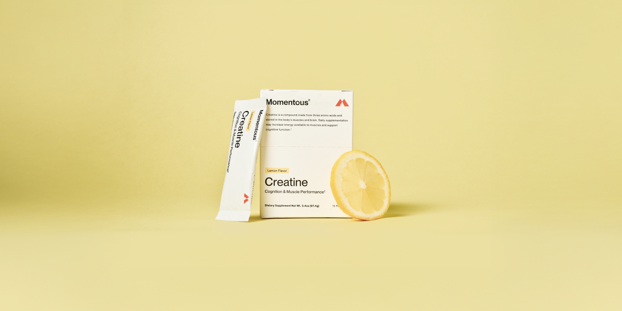 A lemon flavor creatine travel pack, a box of creatine travel packs, and a slice of lemon