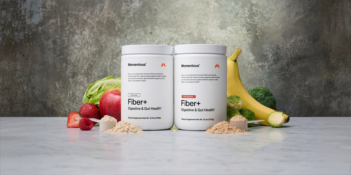 two tubs of Momentous Fiber+ surrounded by fruit and veg