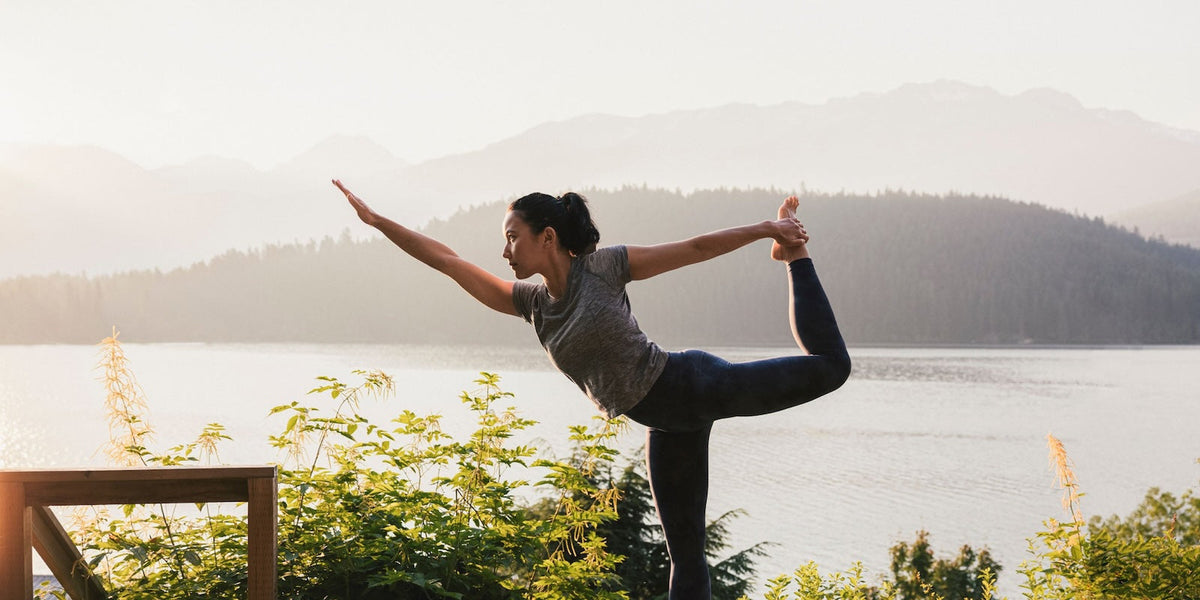 woman doing yoga by lake 