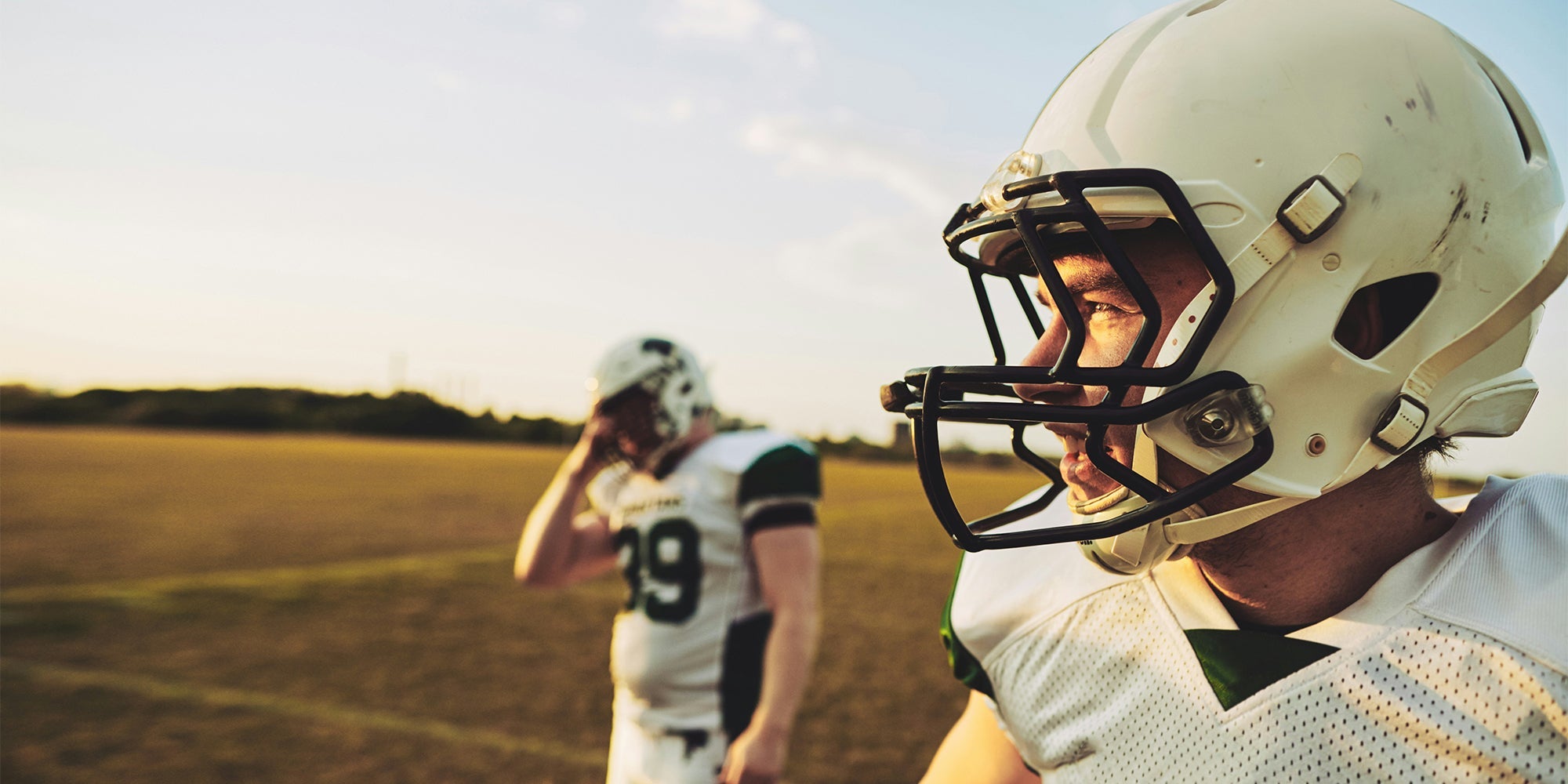 two football players look across a pitch