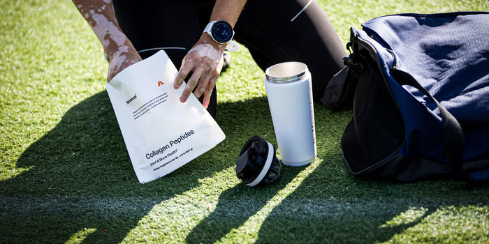 An athlete scoops some collagen peptides powder into their shaker