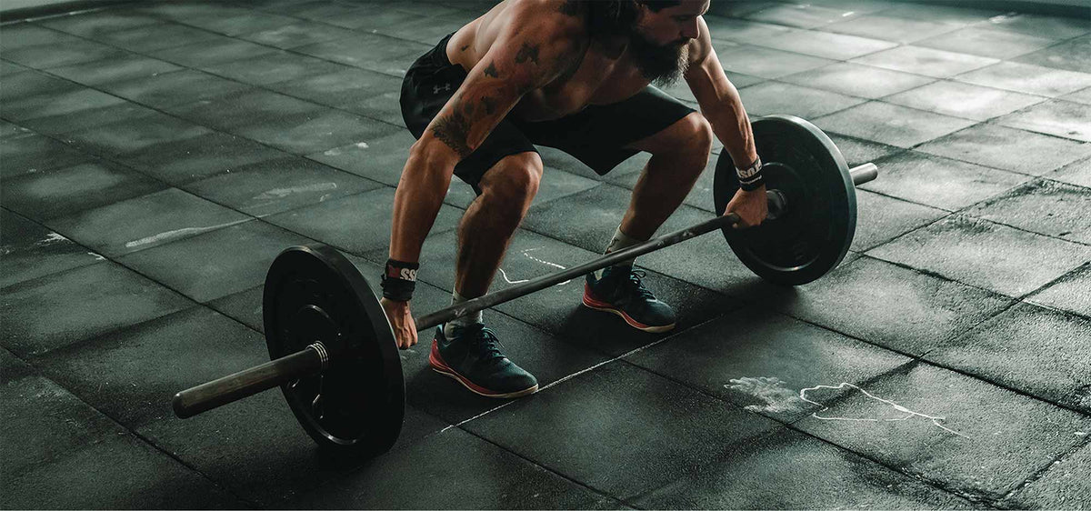 Athlete performing a barbell deadlift in a gym, highlighting strength and performance training fueled by creatine.