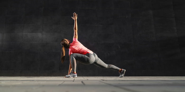 An athletic woman does a whole-body stretch