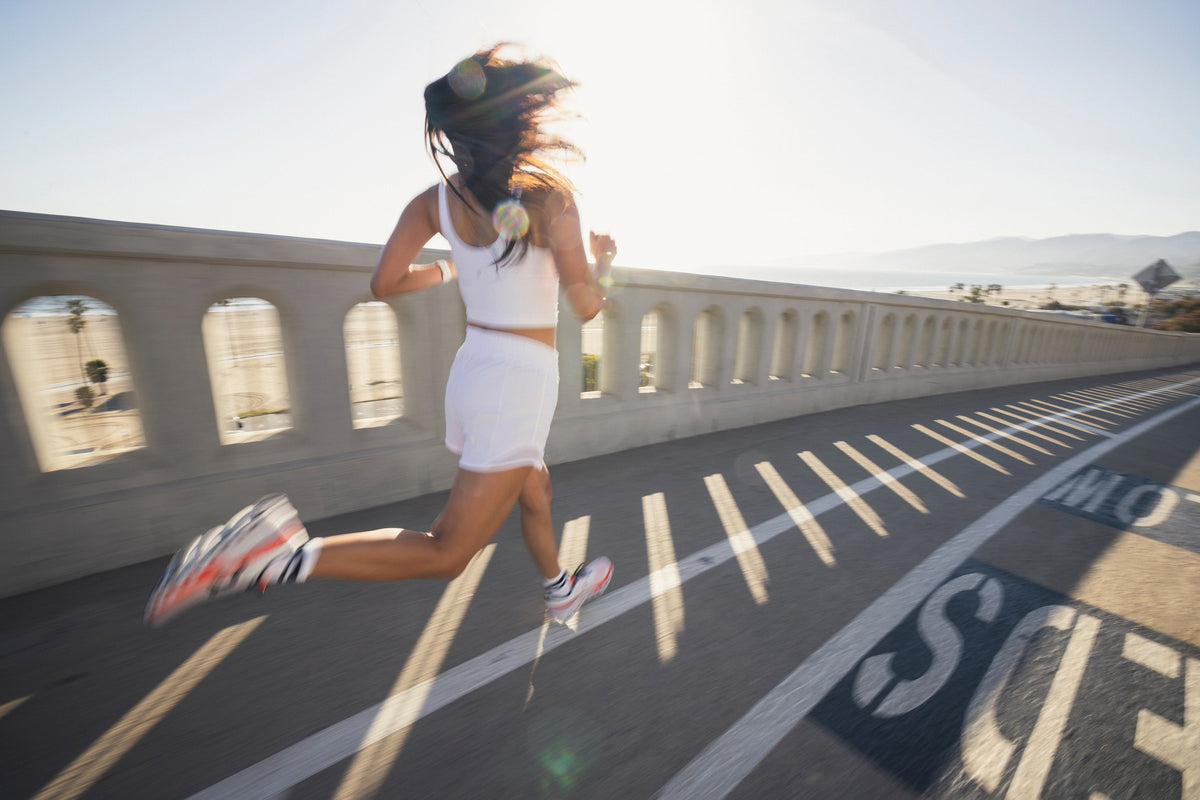 A woman runs across a bridge near the beach