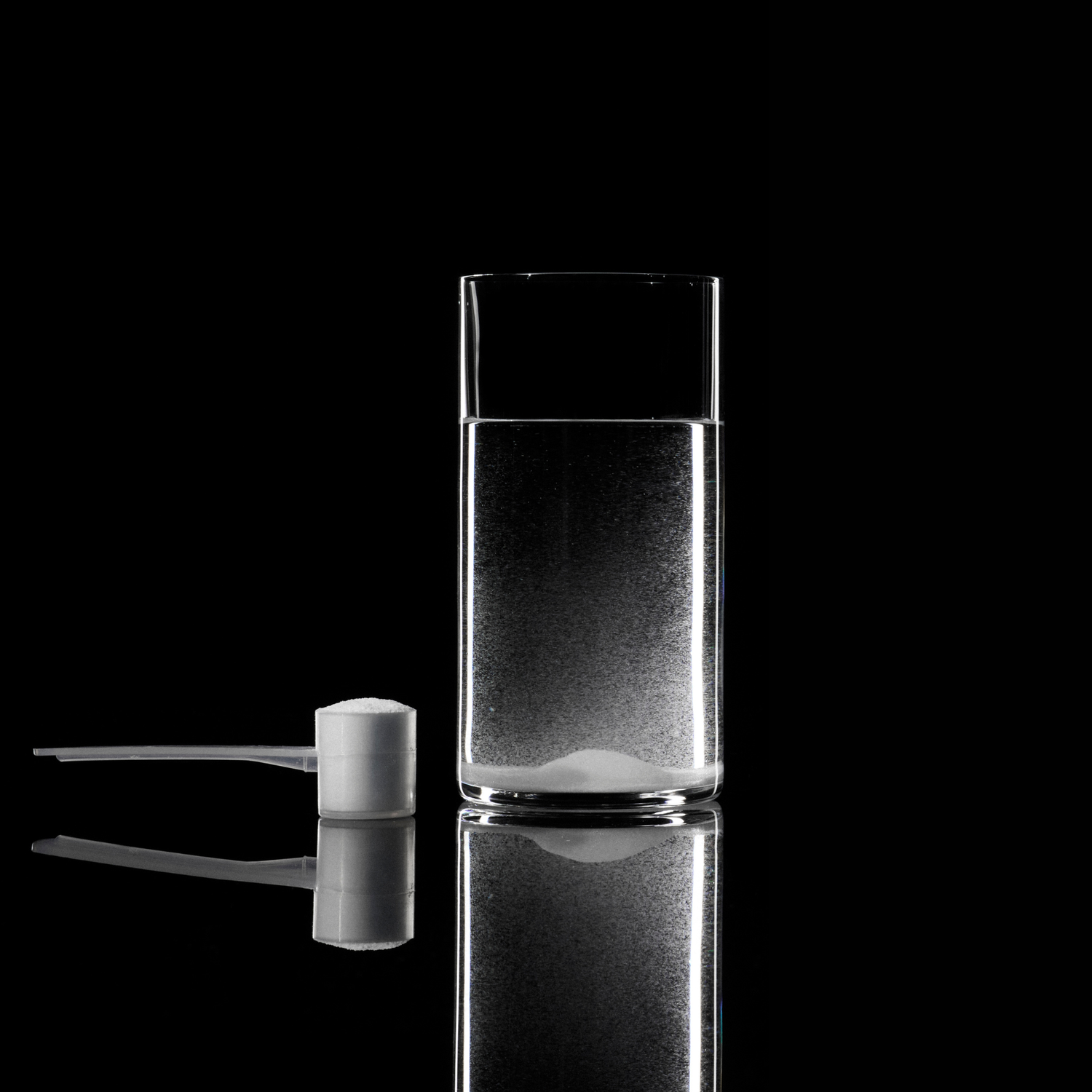Side by side comparison of Momentous Creatine new formula versus old formula showing improved mixability and clarity when dissolved in a glass of water, demonstrating the Signature Spec difference in creatine purity and solubility