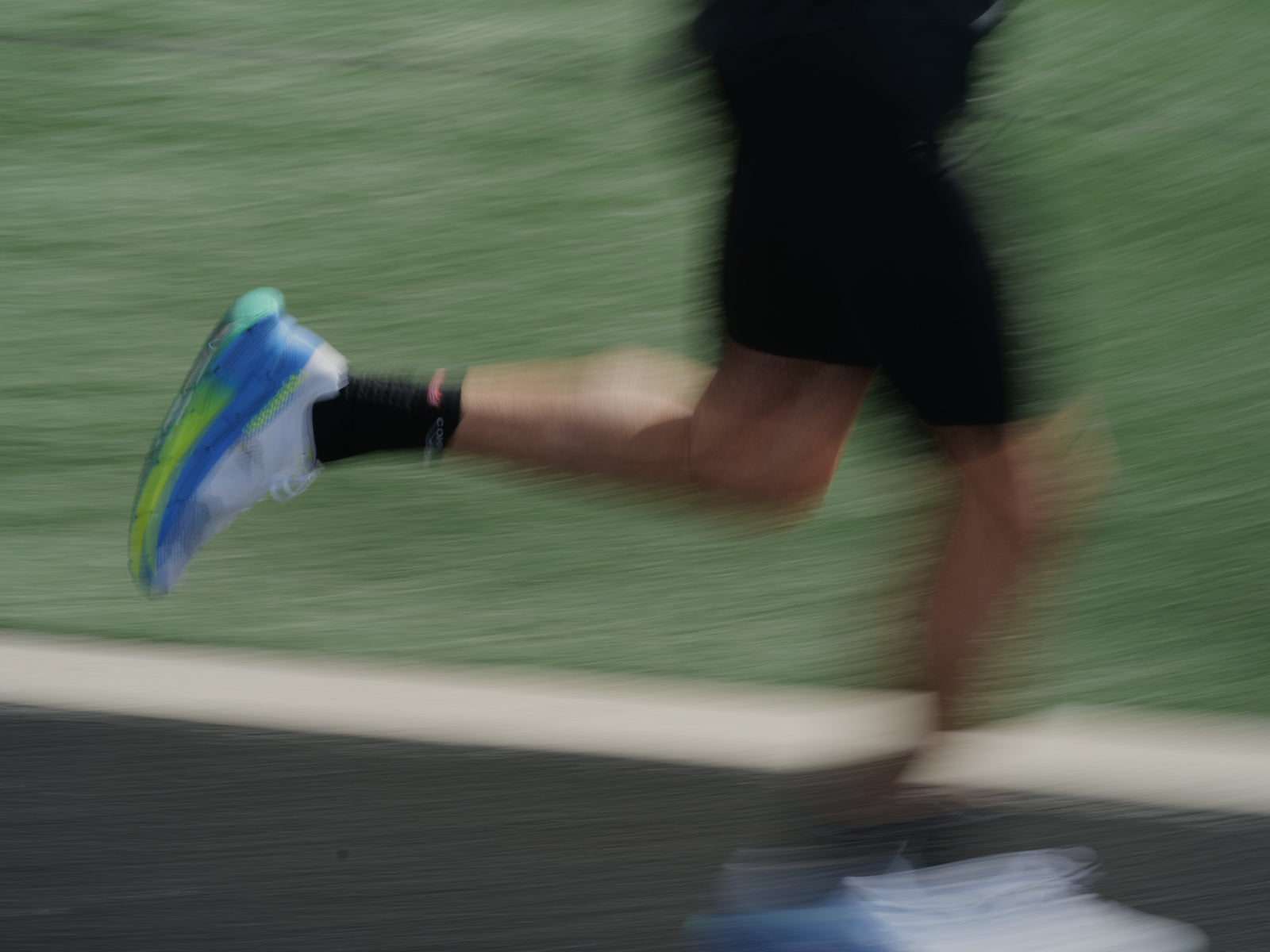 Runner’s leg in motion wearing blue and green shoes, illustrating energy and cardiovascular health benefits of Momentous Berberine.