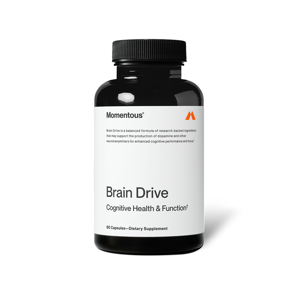 A black bottle of Momentous Brain Drive dietary supplement is shown centered on a black background with a white label. Text on the label reads: “Momentous®” “Brain Drive is a balanced formula of research-backed ingredients that may support the production of dopamine and other neurotransmitters for enhanced cognitive performance and focus.†” “Brain Drive” “Cognitive Health & Function†” “60 Capsules—Dietary Supplement”