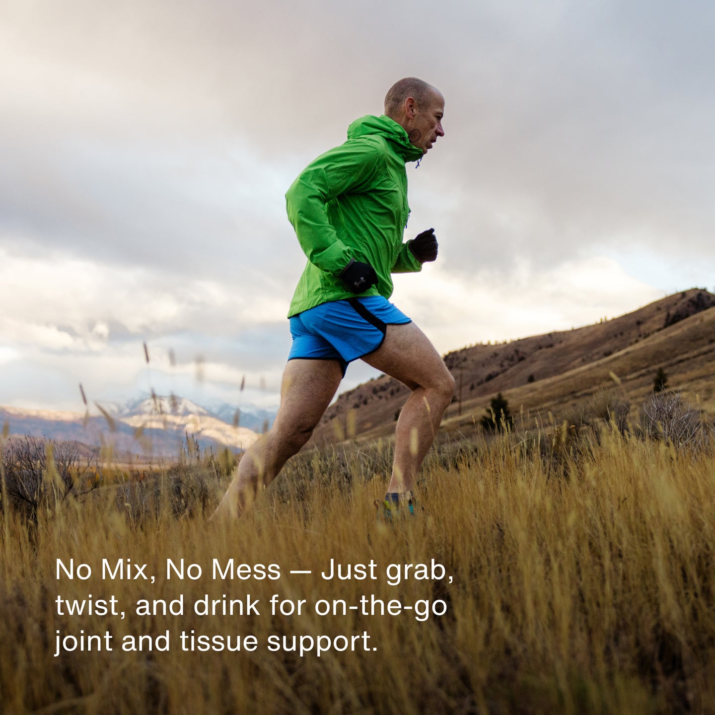 Active man trail running in the mountains wearing a green jacket and blue shorts, with text highlighting the on-the-go joint and tissue support of Momentous Collagen Shot.