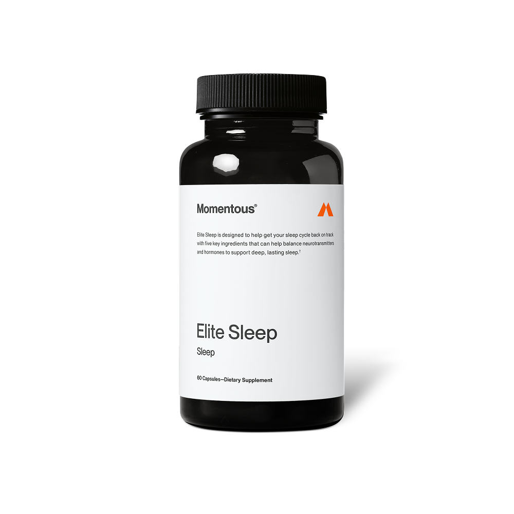 Black bottle of Momentous Elite Sleep dietary supplement on a black background. Label reads: “Momentous,” “Elite Sleep is designed to help get your sleep cycle back on track with five key ingredients that can help balance neurotransmitters and hormones to support deep, lasting sleep†.” Product name reads: “Elite Sleep,” “Sleep,” and “60 Capsules—Dietary Supplement.”