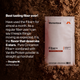 White packet of Momentous Fiber+ Pure Cinnamon dietary supplement labeled as single use travel pack on brown textured backgro