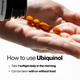 Close-up of a hand holding four orange softgel capsules, with a black Momentous bottle tipped above it. Text: How to use Ubiquinol, Take 1 softgel daily in the morning, Can be taken with or without food.