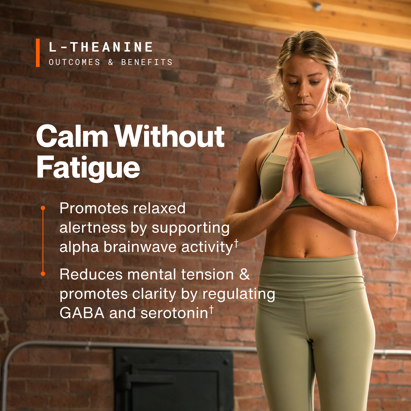 Woman in olive activewear standing with hands together in a brick-walled studio. L-Theanine outcomes and benefits, Calm Without Fatigue: promotes relaxed alertness by supporting alpha brainwave activity; reduces mental tension and promotes clarity by regulating GABA and serotonin. (280 chars)