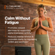 Woman in olive activewear standing with hands together in a brick-walled studio. L-Theanine outcomes and benefits, Calm Without Fatigue: promotes relaxed alertness by supporting alpha brainwave activity; reduces mental tension and promotes clarity by regulating GABA and serotonin. (280 chars)
