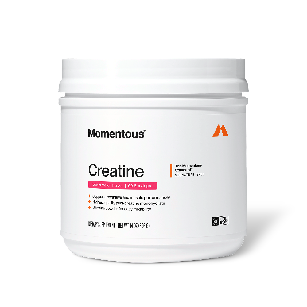 Front view of a Momentous Creatine tub, Watermelon Flavor, 60 Servings. White tub with white lid, Momentous logo and orange 'M' icon. Label reads 'Creatine' with pink Watermelon Flavor banner. 'The Momentous Standard Signature Spec' badge at top right. Benefits: supports cognitive and muscle performance, highest quality pure creatine monohydrate, ultrafine powder for easy mixability. Label shows: Dietary Supplement, Net Wt. 14 oz (396 g), NSF Certified Sport seal.