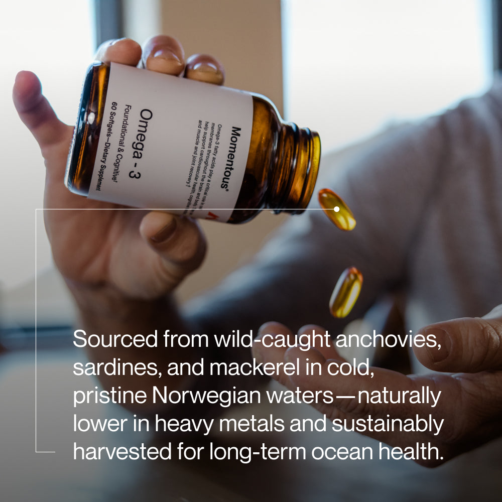 A person pours omega-3 capsules from a brown glass bottle into their hand, with the label partially visible. Text on the image reads: “Sourced from wild-caught anchovies, sardines, and mackerel in cold, pristine Norwegian waters—naturally lower in heavy metals and sustainably harvested for long-term ocean health.”