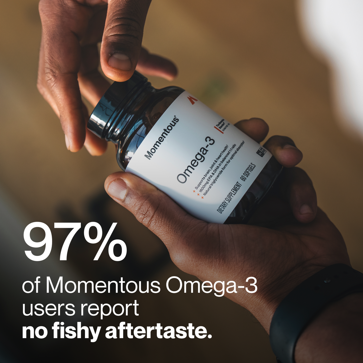 97 percent of Momentous Omega-3 users report no fishy aftertaste, with a 60 softgel bottle passed between two hands. (116 chars)
