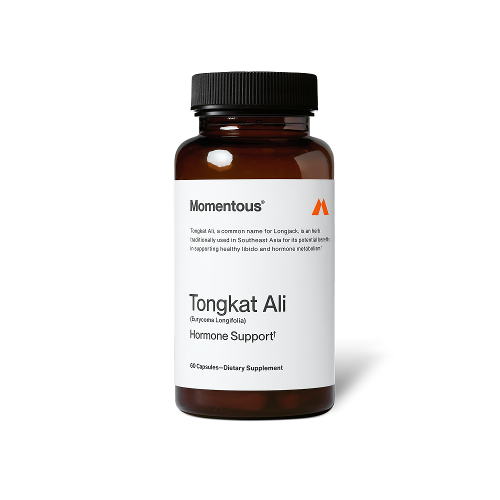 A brown glass bottle of Momentous Tongkat Ali dietary supplement is centered on a black background with a white label. Text on the label reads: “Momentous®” “Tongkat Ali, a common name for Longjack, is an herb traditionally used in Southeast Asia for its potential benefits in supporting healthy libido and hormone metabolism.†” “Tongkat Ali (Eurycoma Longifolia)” “Hormone Support†” “60 Capsules—Dietary Supplement”